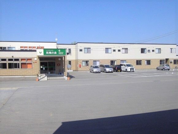 介護車両の前にいる車椅子に乗った高齢者と介助をする介護士