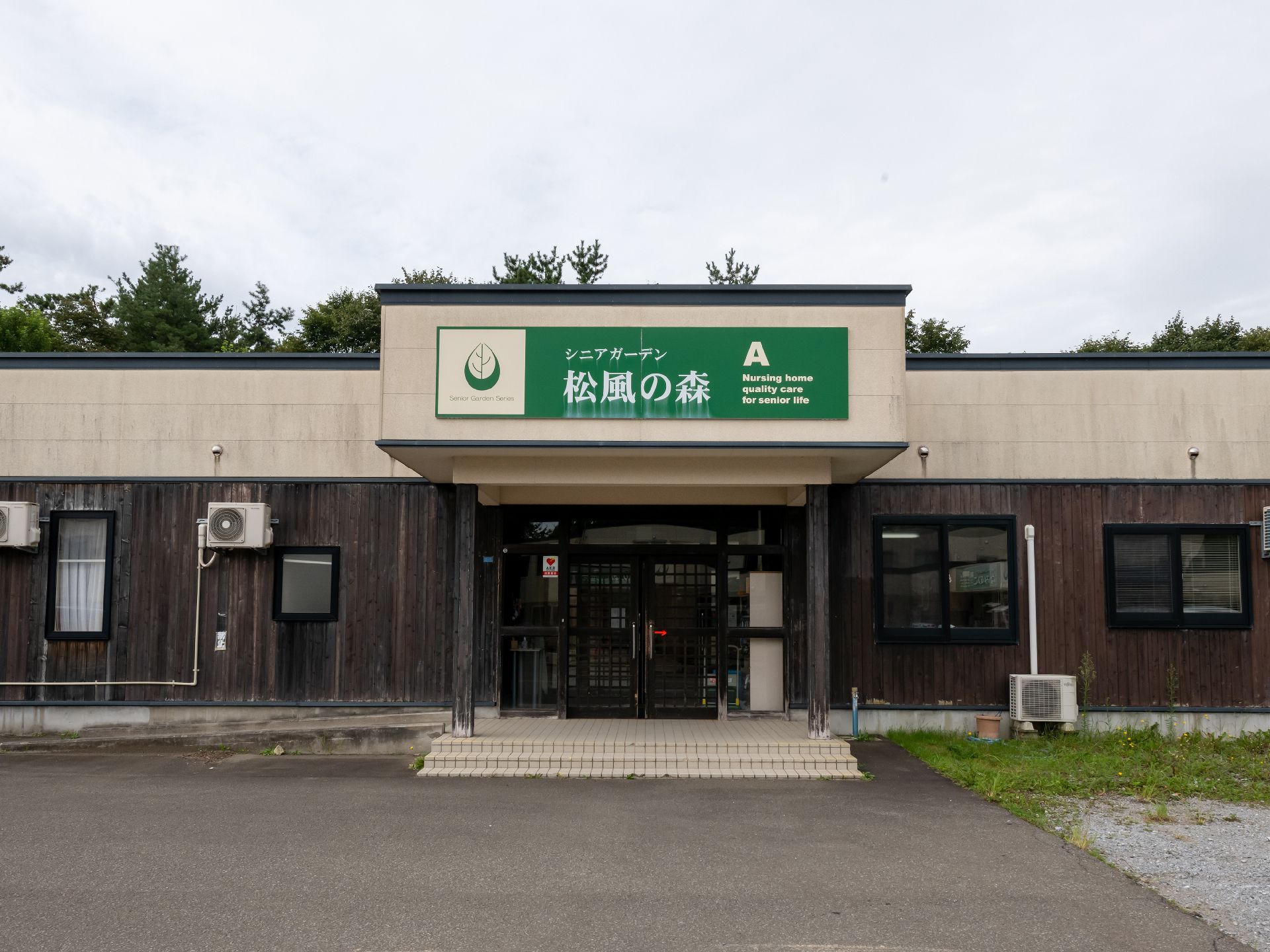 輪になってレクリエーションをする高齢女性と女性スタッフ