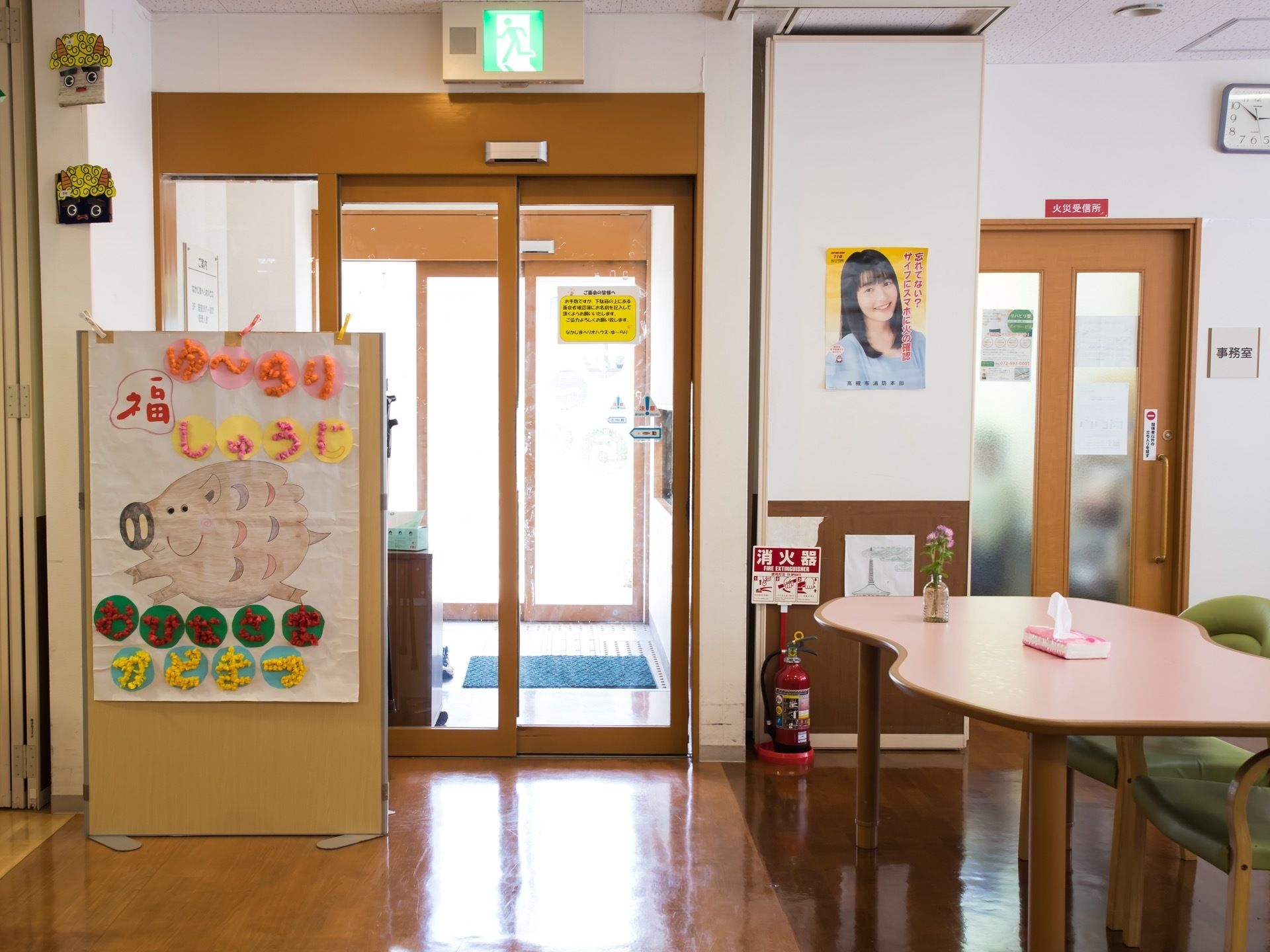 玄関からホールまで２枚の自動扉が続いている。入口の横に手作りのイラストがあり、干支のいのししが描かれている。
