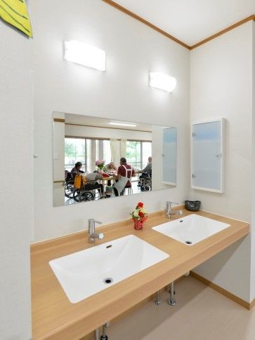 木の風合いが印象的なデザインの洗面台の様子。施設内の設備の写真