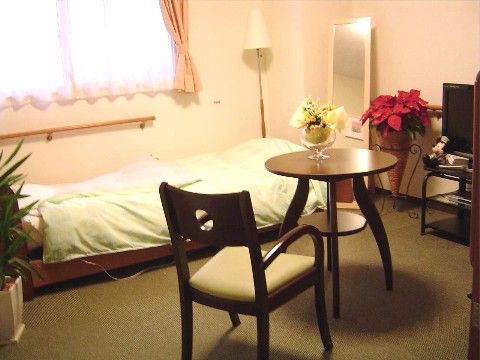 「ココファンメゾン四之宮II」の居室。ベッドから起き上がれるよう手すりを設置している。