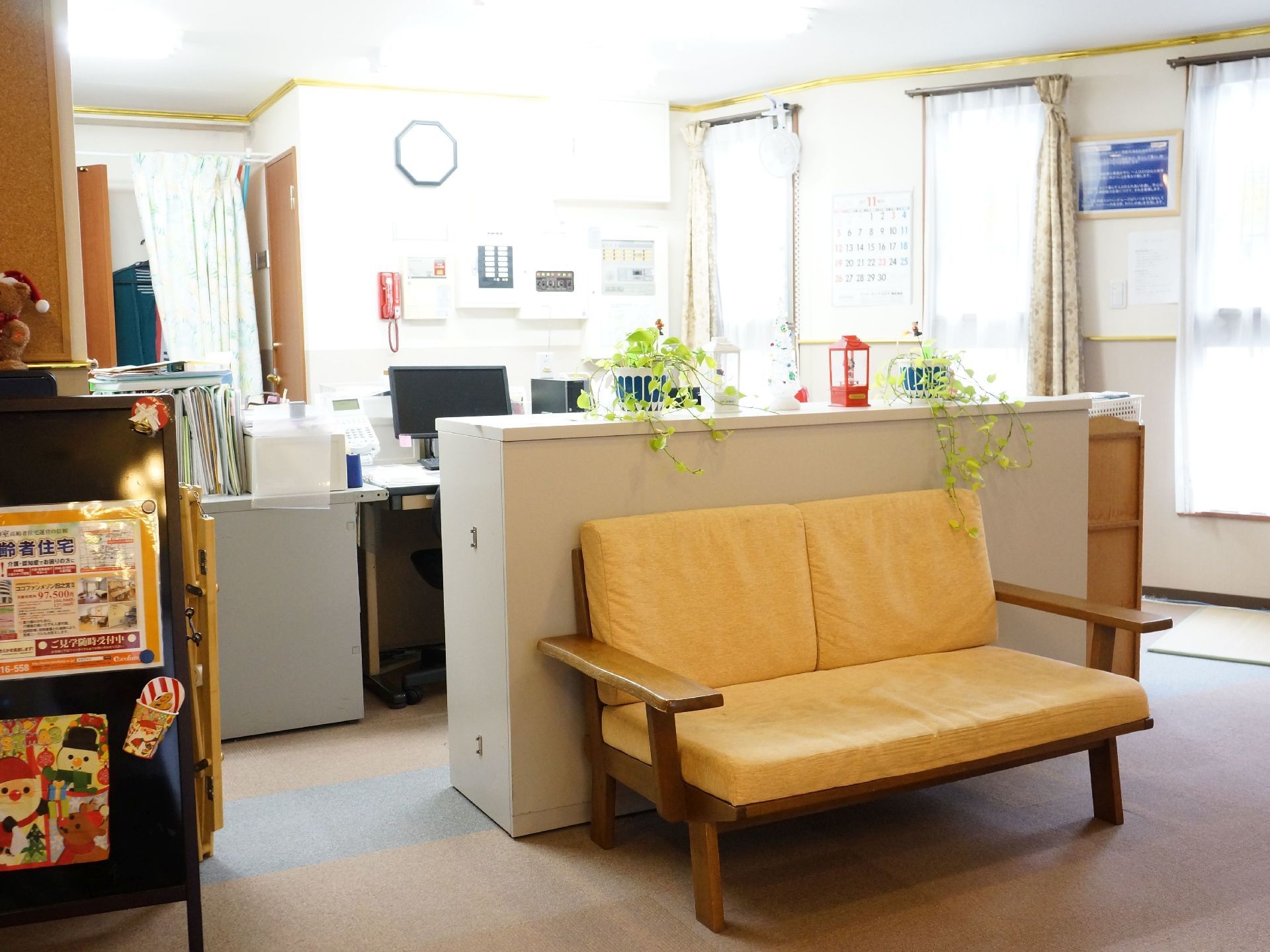 部屋の仕切りに整理棚を設置している。また時計が見やすい所に配備している。反対面には黄色いソファを置いている。
