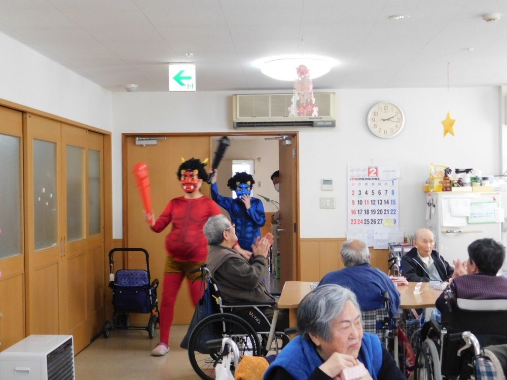 節分のイベントを共有スペースで行っている様子。出入り口には赤鬼と青鬼に扮して金棒を持っているスタッフがいる。