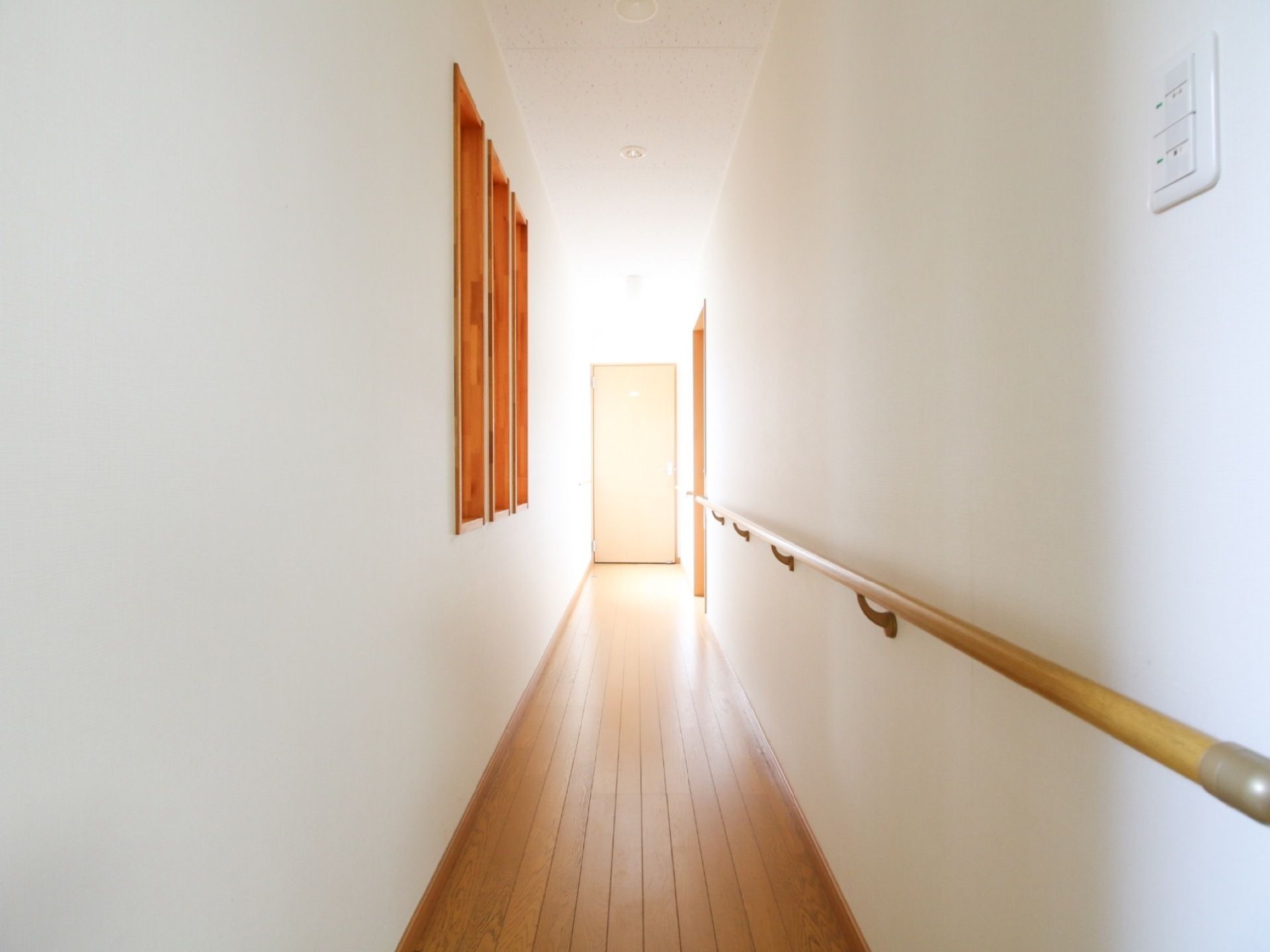 真っ白な壁が美しい通路である。片側の壁には手すりが完備されている。清掃が行き届き、床はピカピカに輝いている。