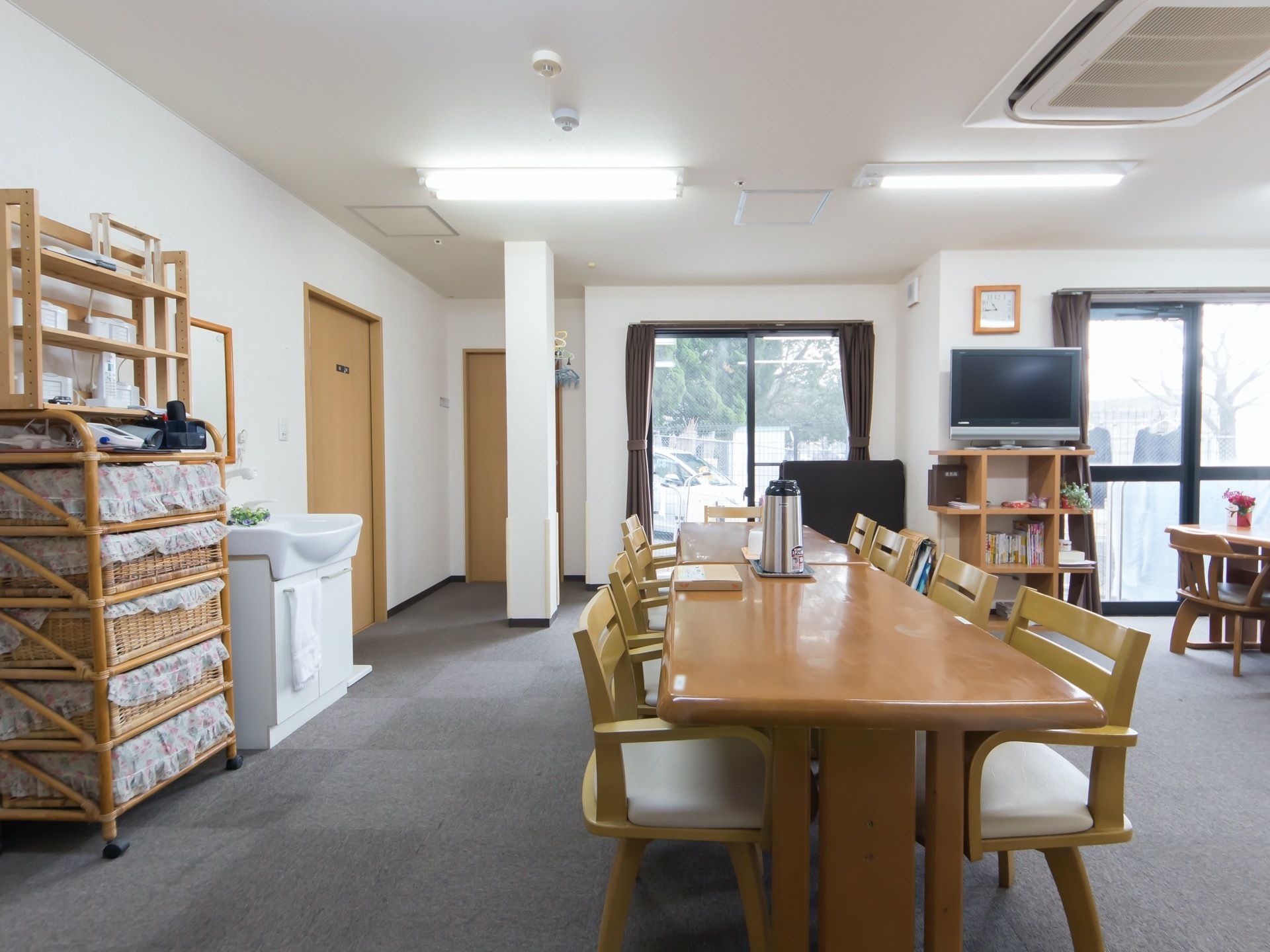 食堂は広々としていて、大型液晶テレビや洗面台が完備されている。床は、転倒時にケガをしにくいカーペット敷きである。