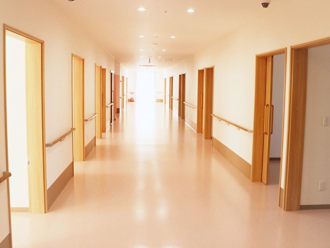 まっすぐな廊下は両サイドに手すりがあり、突き当りに窓がありとても明るい。居室のドアはスライド式。