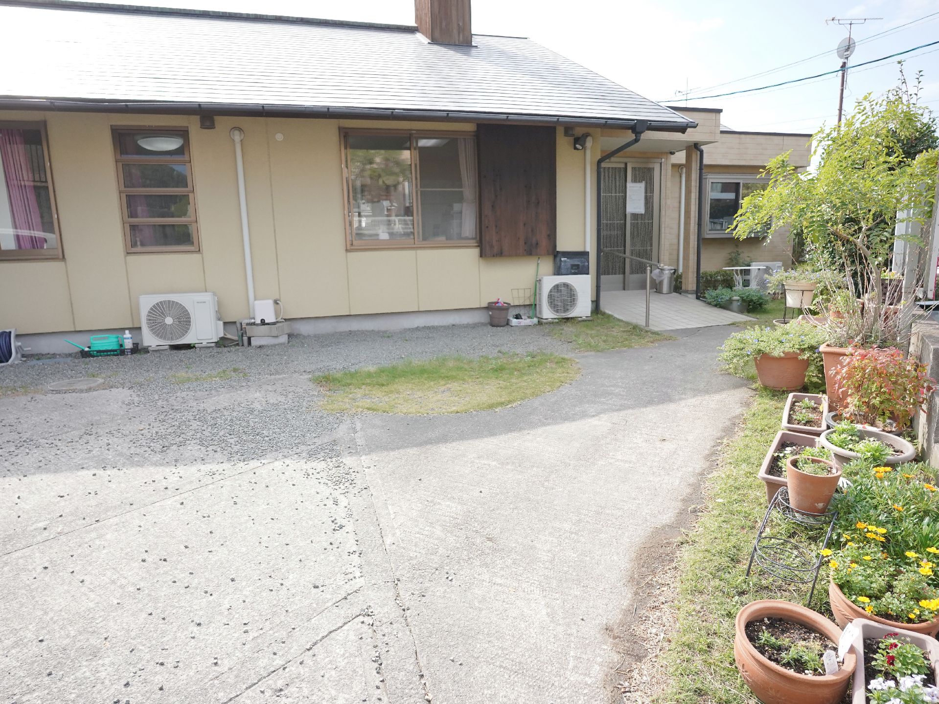 施設前に植物や花が置かれて自然にあふれている外観