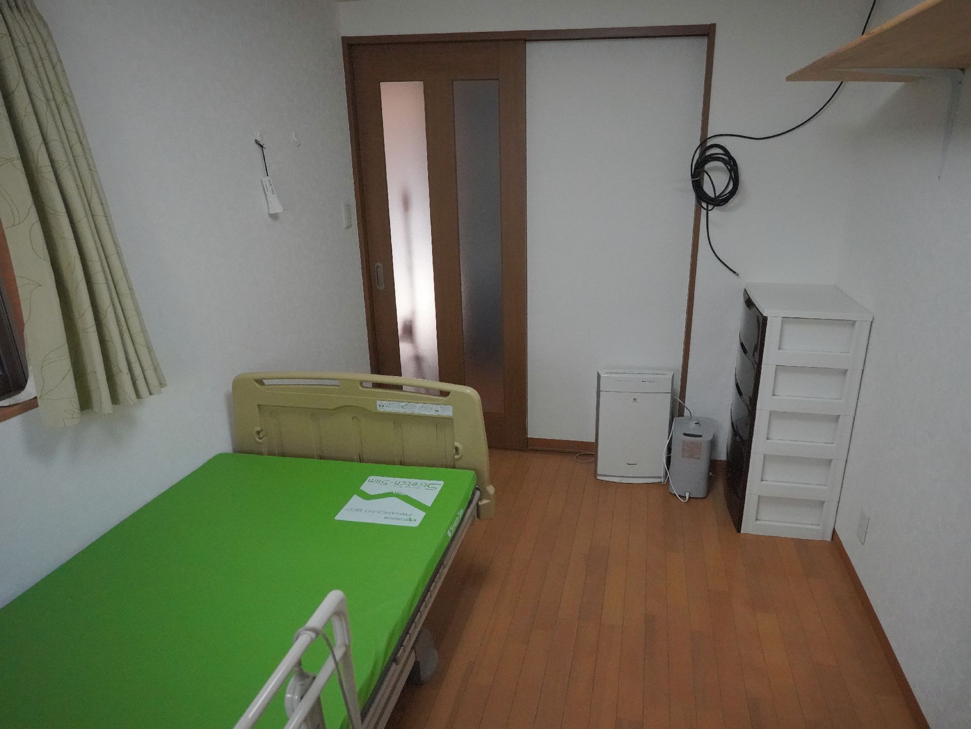 ベッドと収納ケースが写されている様子の居室