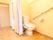 共用トイレは、カーテンで目隠しすることができるようになっている。壁には、斜めに長くて太い手すりが設置されている。
