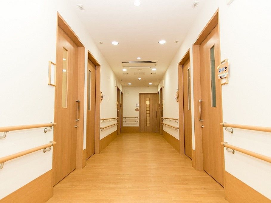 両サイドに手すりと居室ドアが設置されたろうか。木目調の手すりが白い壁によく映える。