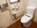 共用トイレの室内。便座横には手すりと温水洗浄便座のほか、給湯ヒーターを取りつけた手洗い器もされている。