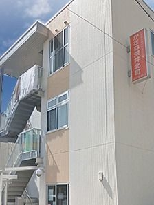 建物の側面から見た様子。屋外にも階段が付き、外壁にはホームの看板がつけられている。