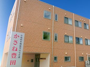 明るい茶色の3階建ての建物。玄関が少し中に入ったデザインとなっているので、屋根ができている。