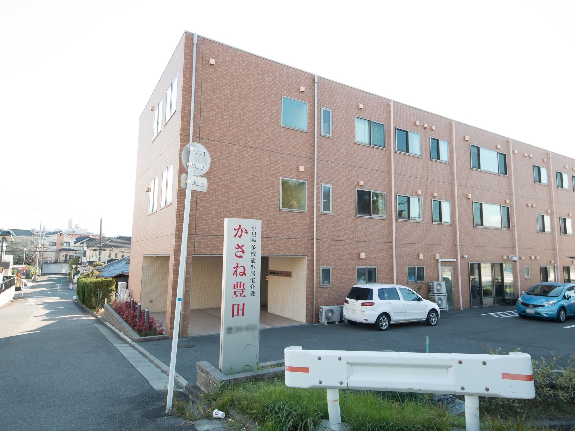 モノトーンのすっきりとした３階建ての施設である。道路沿いに大きな文字で施設名が表示された看板が立っている。