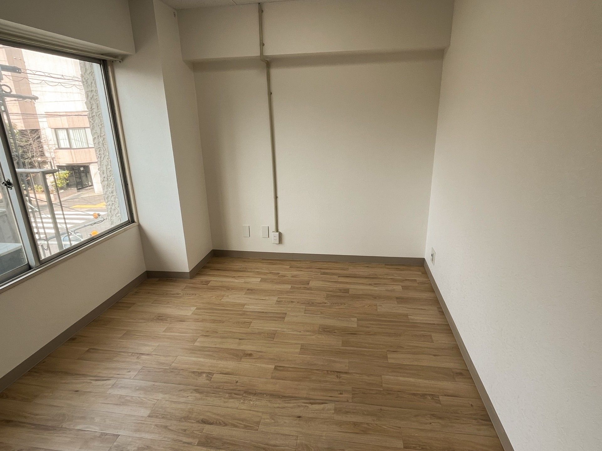 寝具付きのベッドやテレビが置かれた部屋にはエアコンやクローゼットもあり、大きな窓もある。