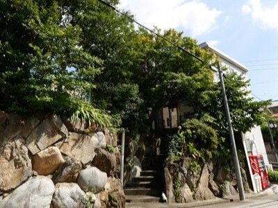 緑に囲まれた階段を昇っていくと2階建ての建物のようなものがある。