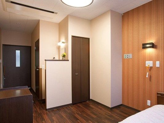 ブラウン系でまとめられた落ち着いた雰囲気の居室。ベッドや収納家具が置かれている。