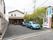 建物と車道までは距離があり、車が複数台停められるようになっている。隣の建物とはフェンスで仕切られている。