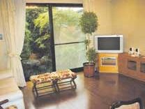 共有スペースには花柄のベンチタイプの椅子やテレビ、観葉植物が置かれ、庭を見ることができる大きな窓が付いている。