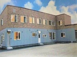 ２階建ての建物はフロアにより外壁の色が異なり、レンガ調の外壁がおしゃれな雰囲気。エル字型で横に長い。