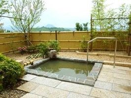 庭園の中にある埋め込み式の露天風呂。安全に入浴できるよう手すりが付いている。
