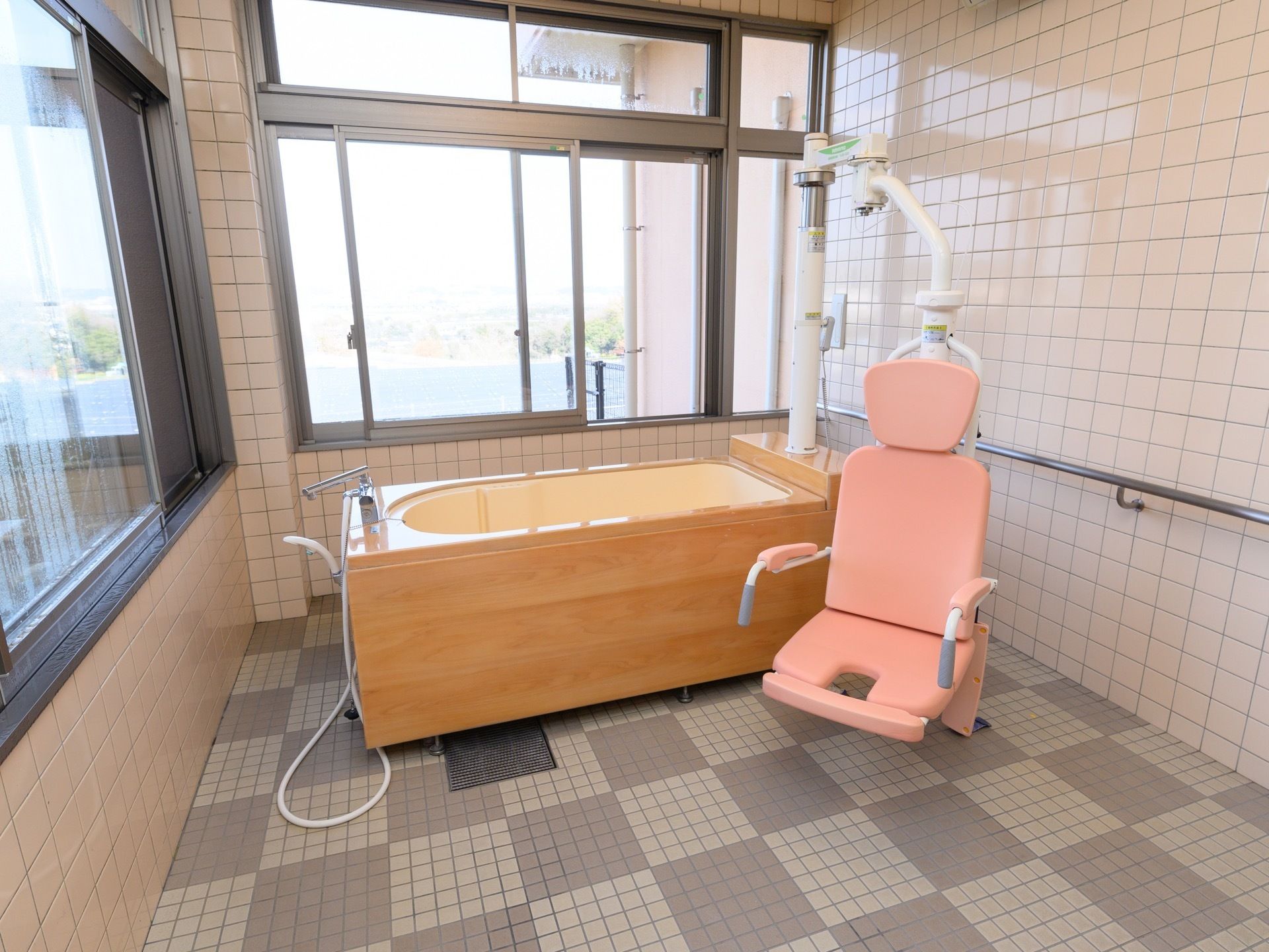 ２方向から採光できる、明るく開放的な浴室にはリフトの付いた介護浴槽が置かれている。座った状態で安全に入浴することができる。