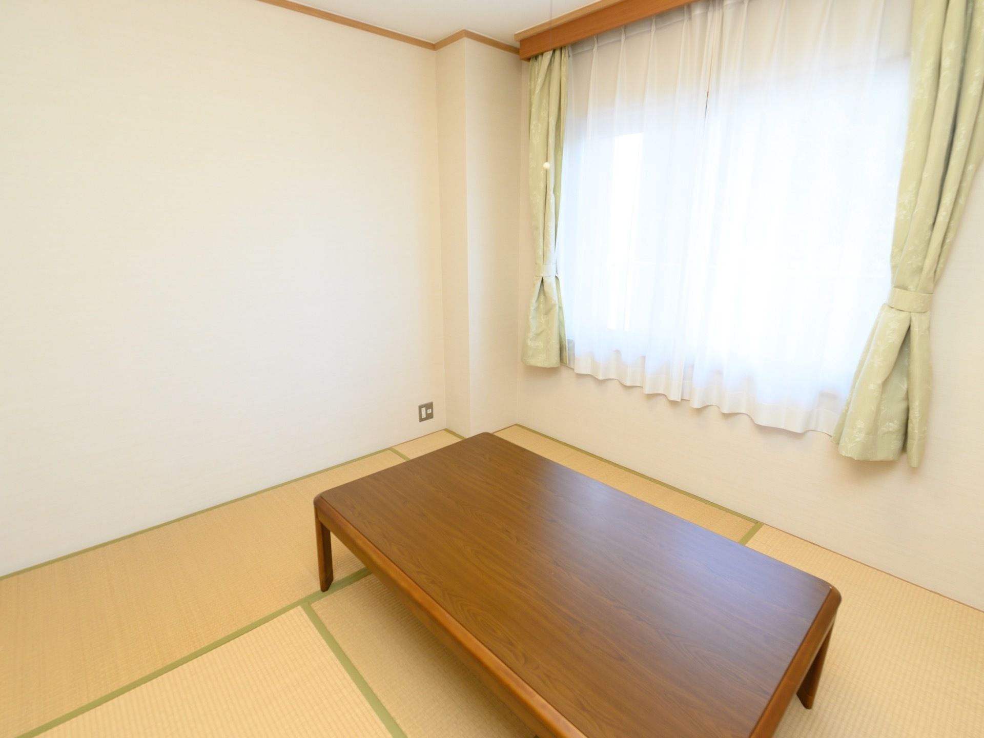 純和風の落ち着いた雰囲気の和室の中央にテーブルが置かれている。窓からは日が良く入り、室内は明るく過ごしやすい。