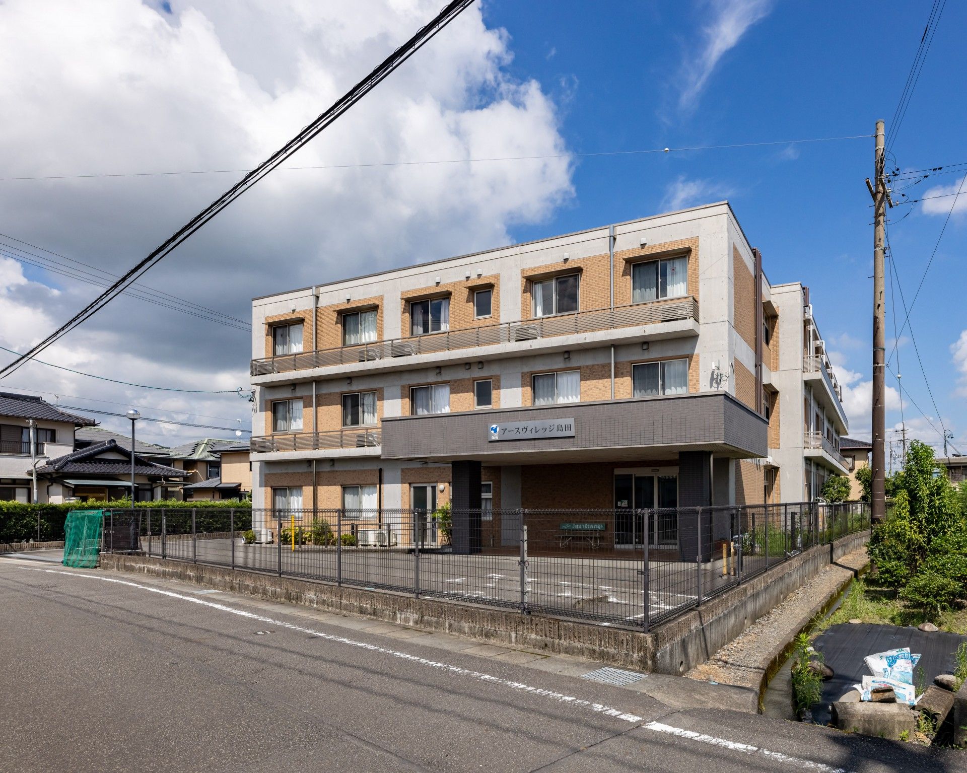 3階建てのオレンジと白の建物