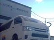 ピンクのエプロンを付けた若い女性スタッフと高齢女性がカルテのようなものを見ながら話している。二人とも真剣な表情。