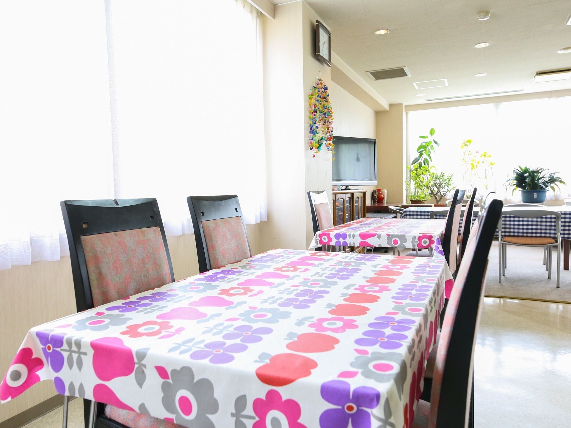 食堂に並べられたテーブルには華やかなテーブルクロスが掛けられている。椅子の背もたれは高く、座り心地がよい。