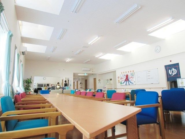 広い食堂には青やピンクのいすが設置された大きなテーブルが置かれ、壁には絵が飾られている。
