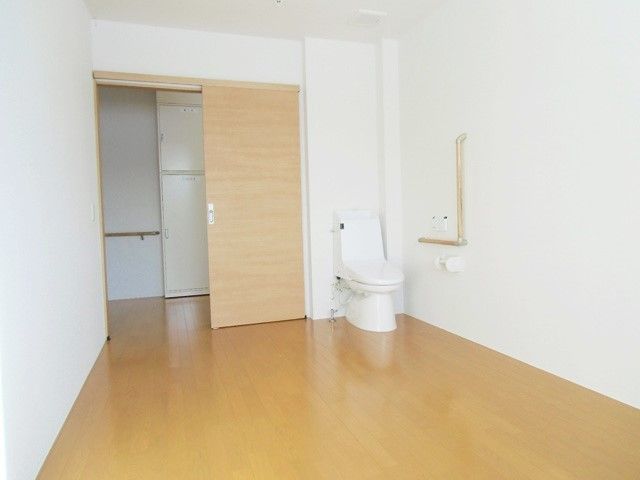 トイレ付きの居室。フローリングで家具はなく、廊下との間に段差はない。