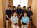 半袖を着た７名の女性スタッフが笑って写真に写っている。和を感じられる空間で、後ろには着物が飾られている。