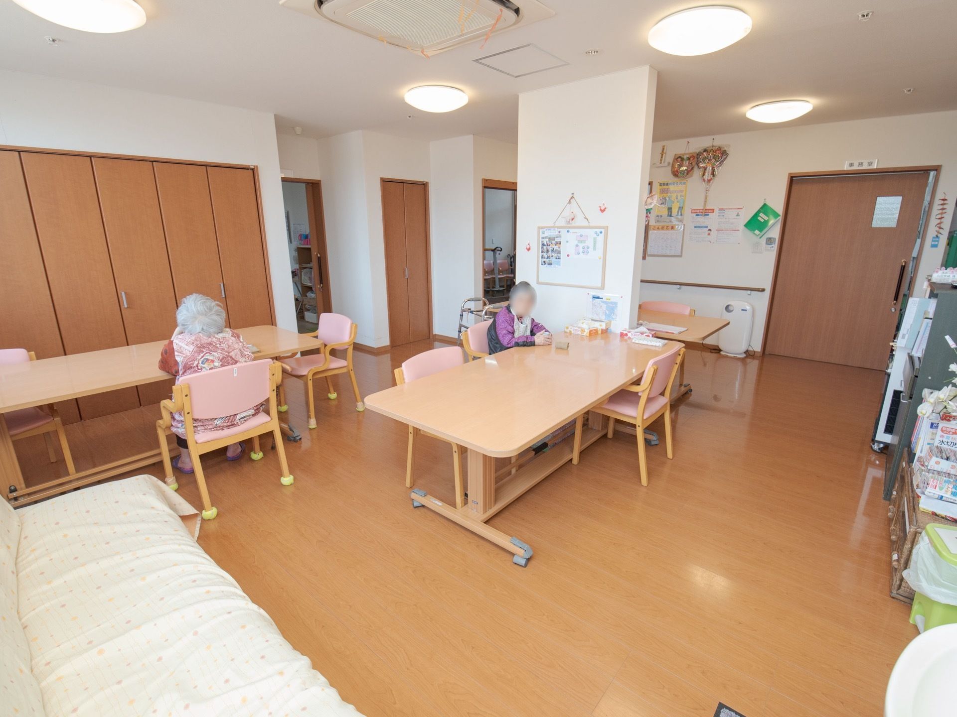 丸い天井照明が多くあり、明るい部屋である。大きなテーブルセットが数組並んでいる。手前には、ソファーが置かれている。
