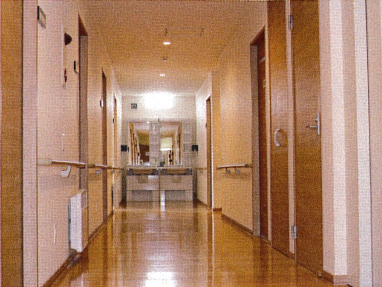 まっすぐな廊下には居室のドアが並んでいる。手すりの設置も全域にある。