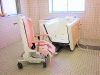 ピンクと白の機械浴槽が置かれた浴室は日当たりもよい。体の状態に合わせて利用できる。