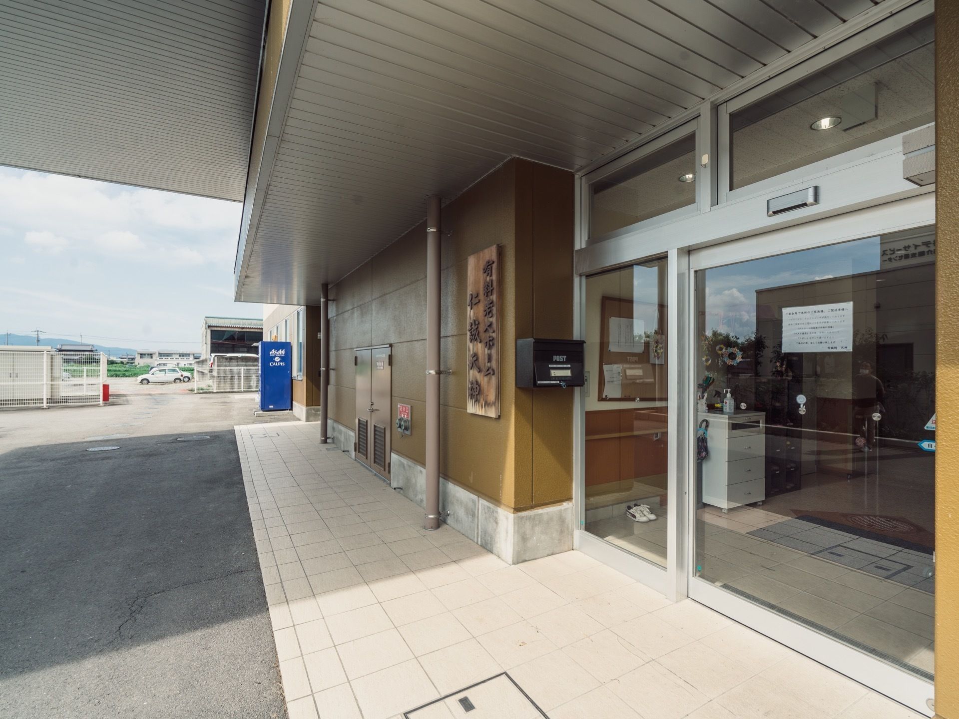 建物には老人ホームとショートステイの２つの施設が入っている。それぞれ玄関口が分かれており、看板が取り付けてある。
