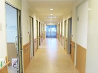 施設内の廊下を写した写真。両側にスライド式引き戸の部屋が並んでいる様子