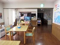木製の家具類が並んでいるリビングの様子。家庭的な雰囲気の施設内の写真