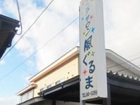 シニアサロンニュー風ぐるまの看板。奥のほうに建物が見えている写真