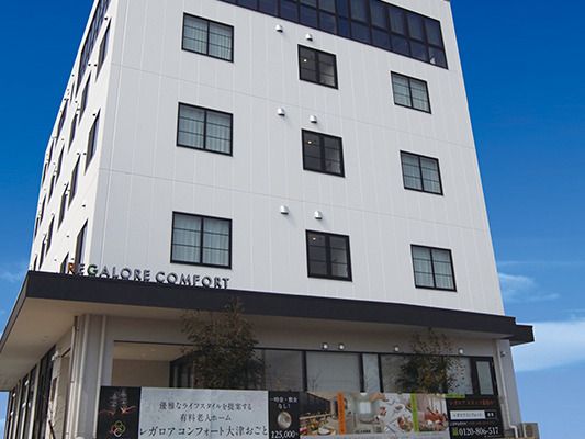 白を基調とした手に長い建物は日当たりのいい場所に建っている。玄関の屋根にはホーム名がアルファベットで書かれている。