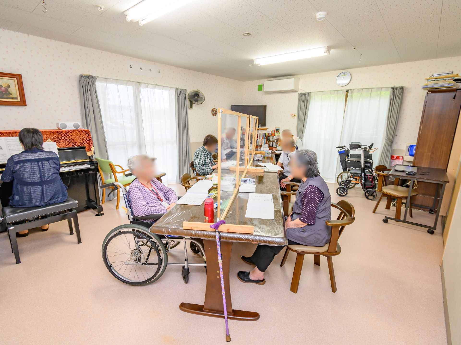ピアノを弾く女性とレクリエーションを行う入居者様