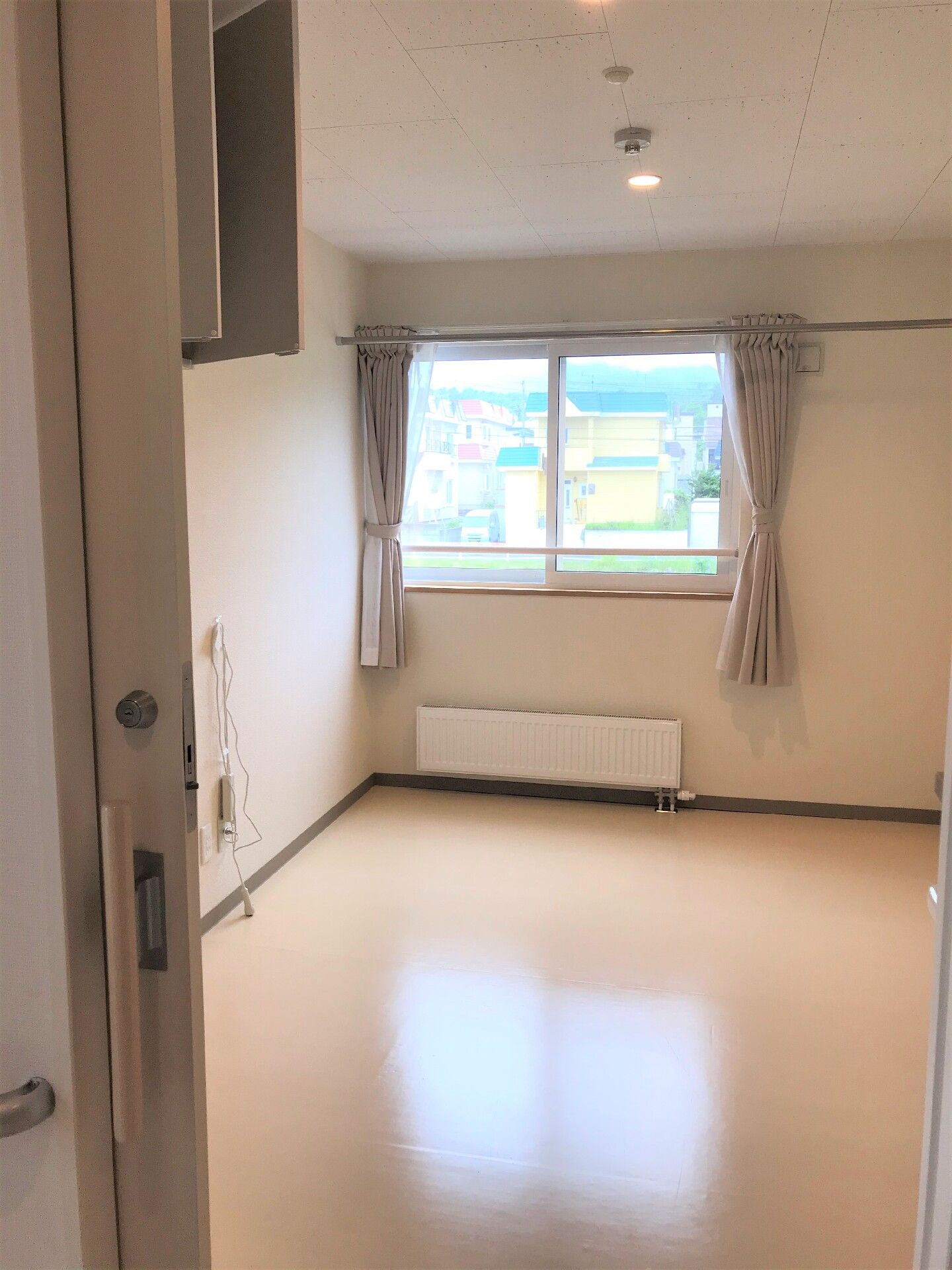 屋外の芝生の上に座って楽しそうに話をしている高齢夫婦と女性の姿