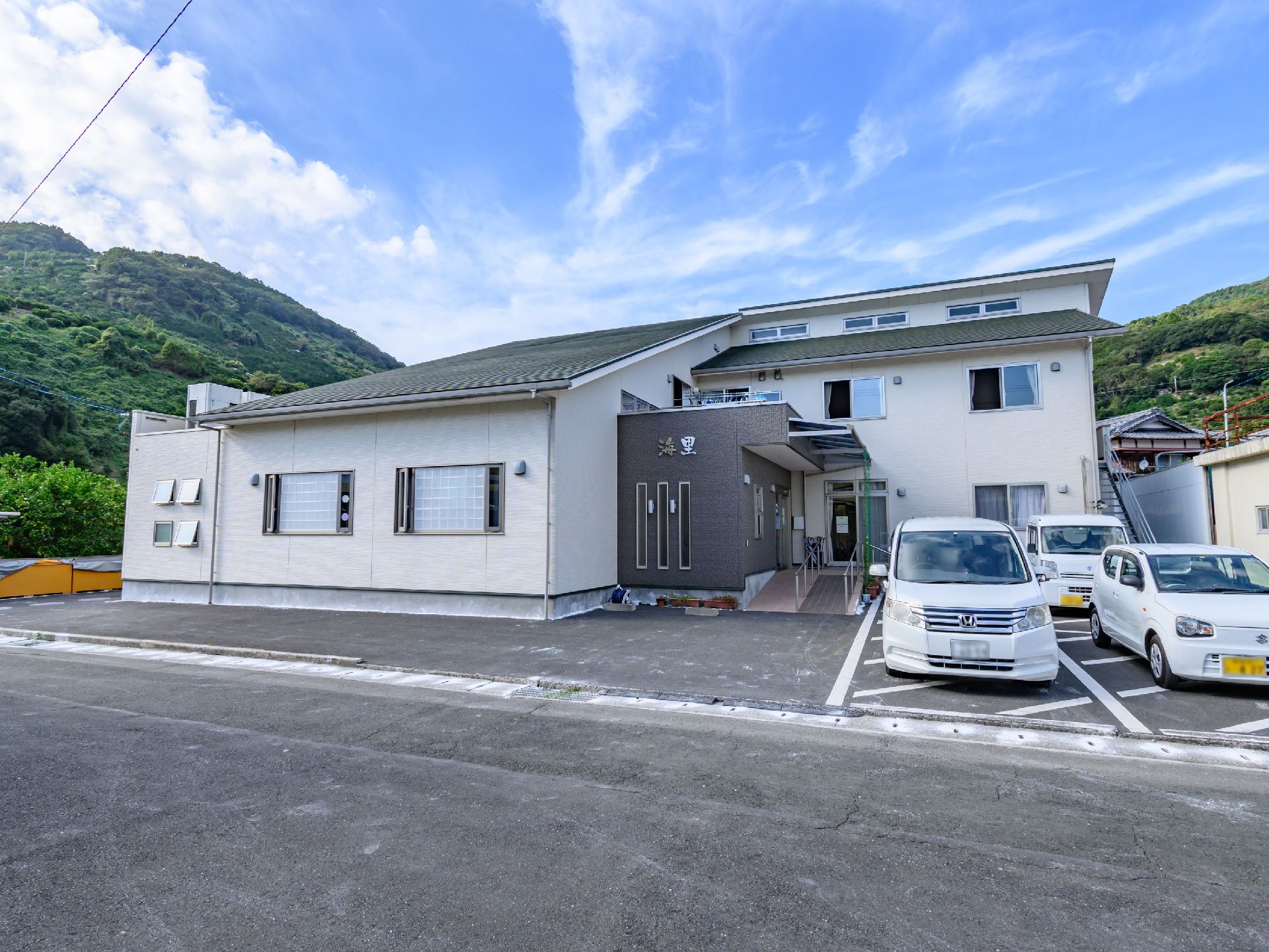 広い駐車場と看板が立っている介護施設