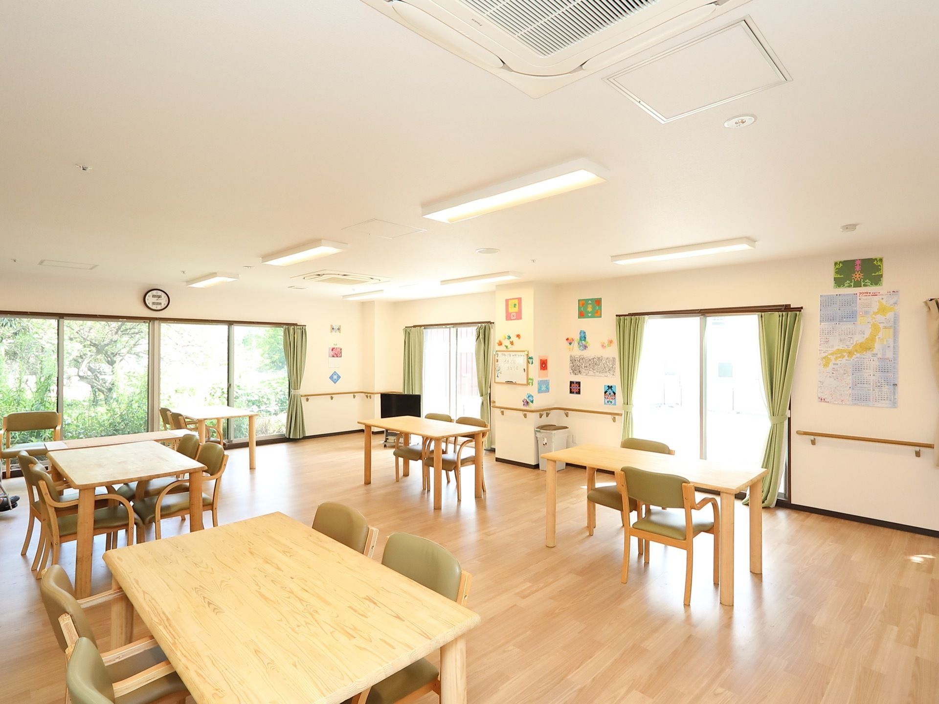 日中、入居者様がお食事やレクリエーションの際に集う大きな共有スペースである。庭の草木が目の保養でもあり、外からの目隠しともなっている。