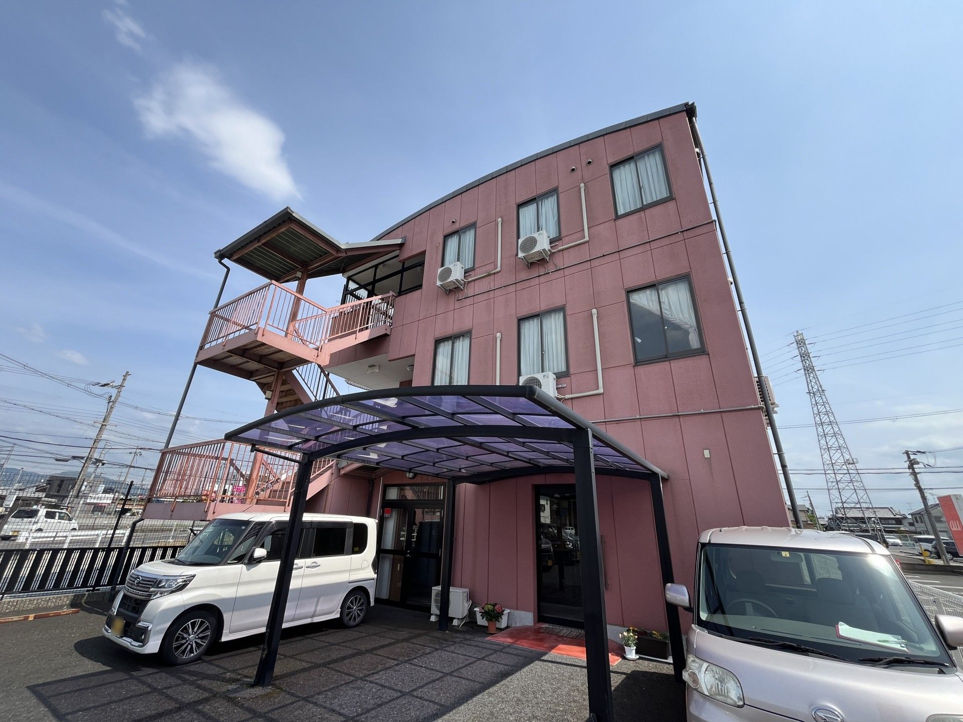 ピンクの建物と駐車場
