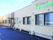 ブラウンを基調とした外観。玄関先には屋根が付き、建物前には駐車スペースがある。