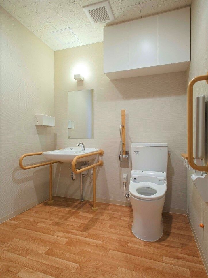 呼び出しボタンが付いた広いトイレ。手洗い場やトイレには両サイドに手すりが付き、出入り口にも手すりがある。