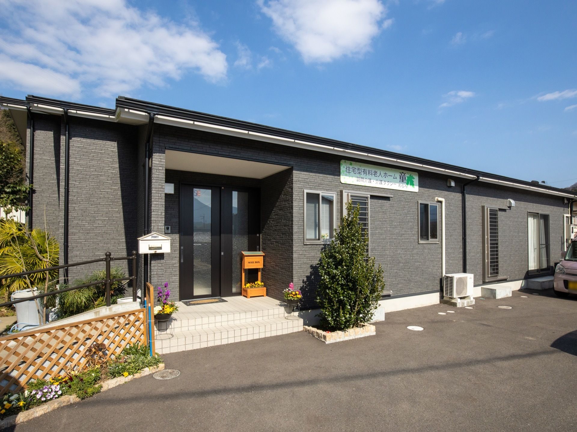 平屋風の建物になっている。外壁は落ち着いたグレー調に施されており、施設名が記された看板が設置されている。