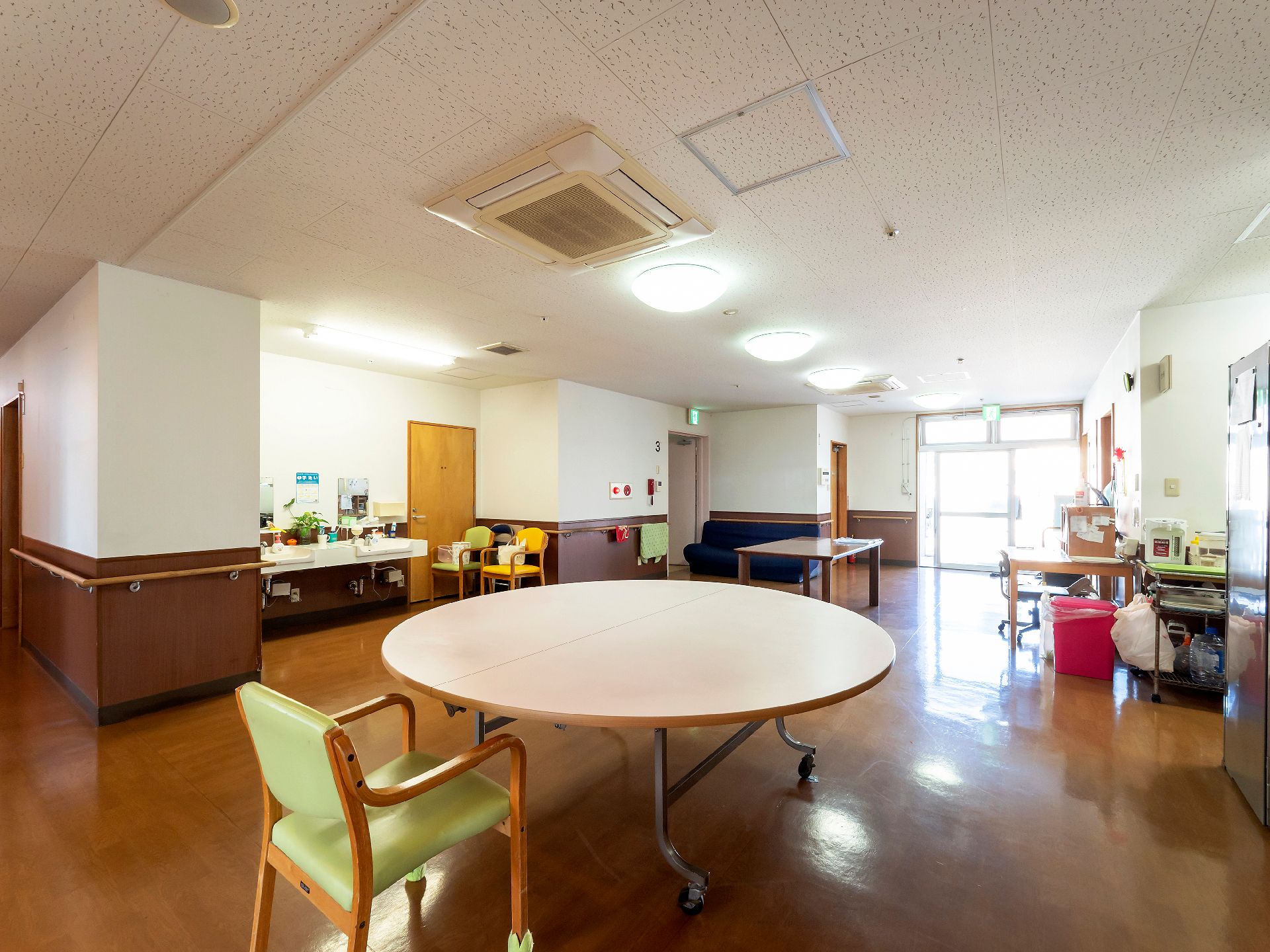 車椅子に乗った高齢女性の介助をする男性ヘルパー